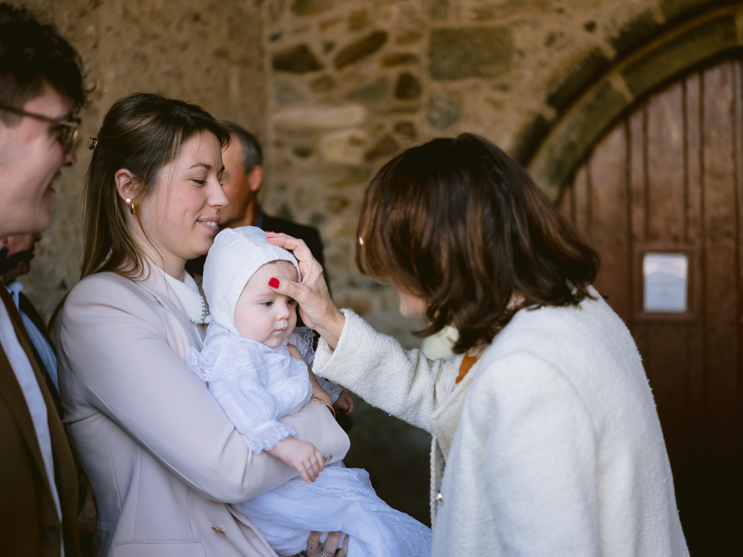 Une grand-mère fait le signe de croix à sa petite-fille avant le baptême